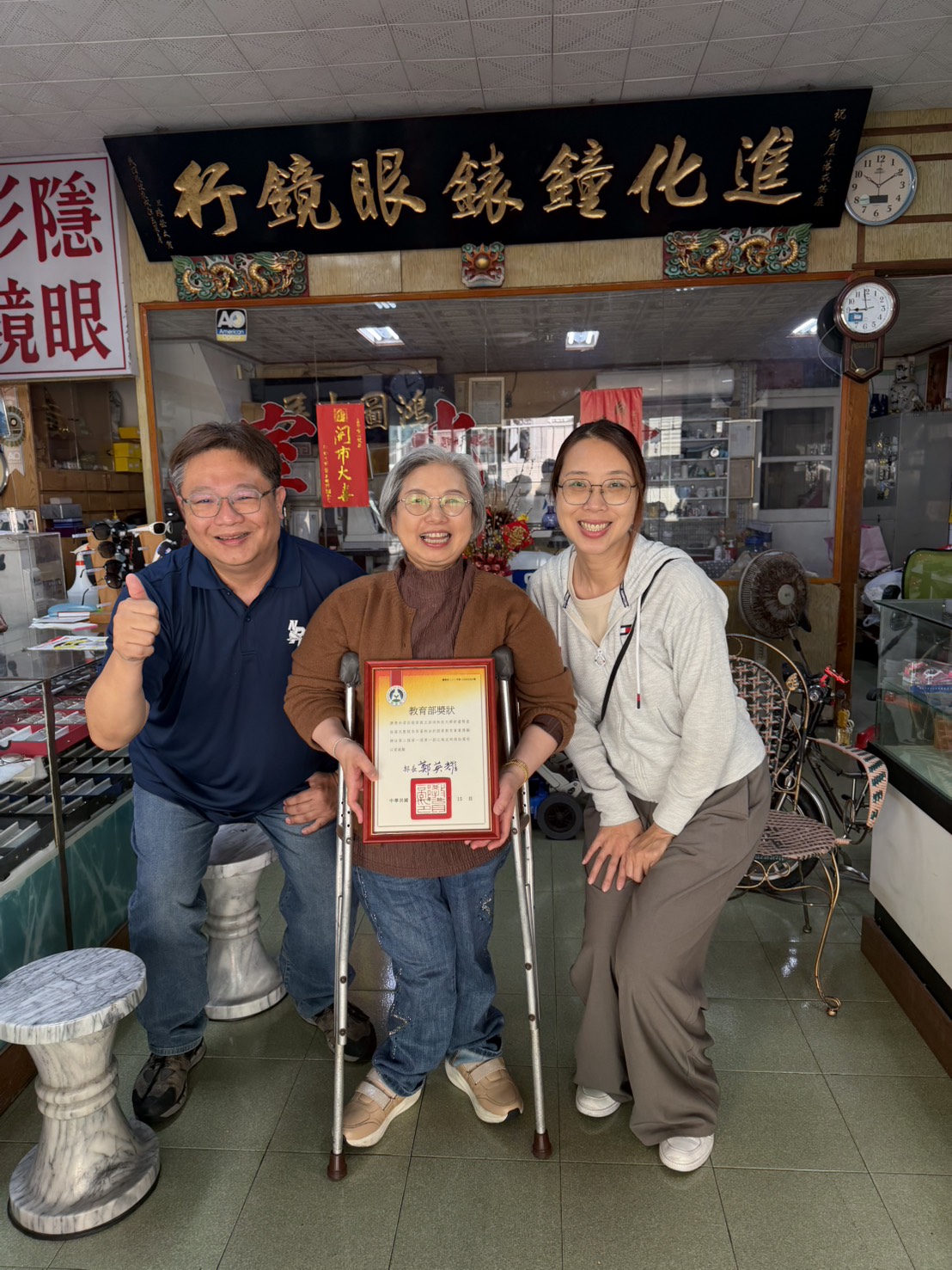 系主任呂峻益老師與班導吳千慧老師代為頒贈獎狀予陳青妙女士